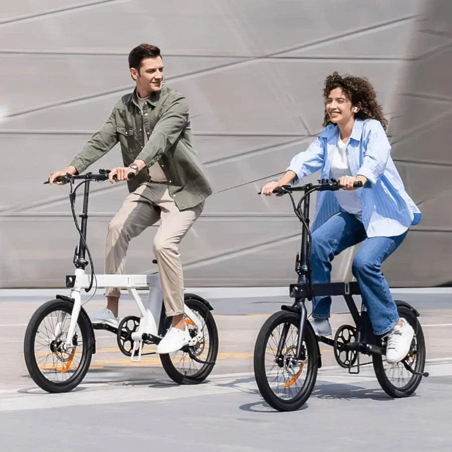 Two individuals riding stylish folding electric bikes on a smooth urban pathway, showcasing convenience and eco-friendly commuting.