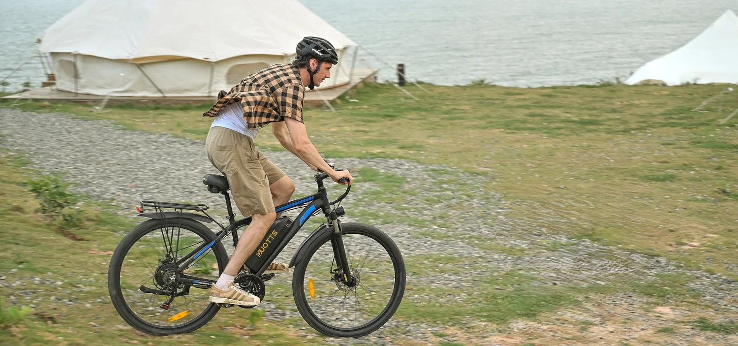 man with black helmet rides DUOTTS C29 E-BIKE on off road path beside the sea